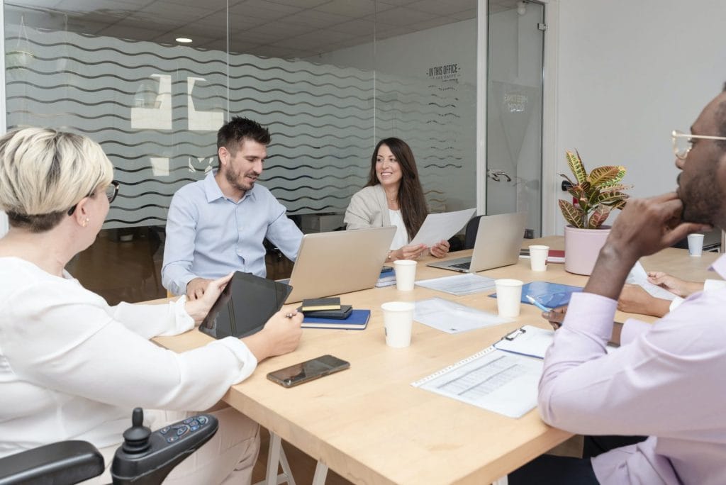 group of young corporate people working together in a boardroom on a marketing project