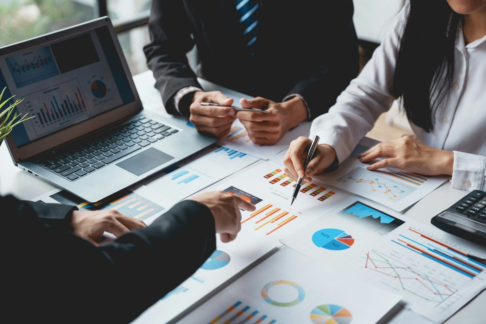 Group of business people meeting to plan, analyze, graph and chart corporate growth to plan
