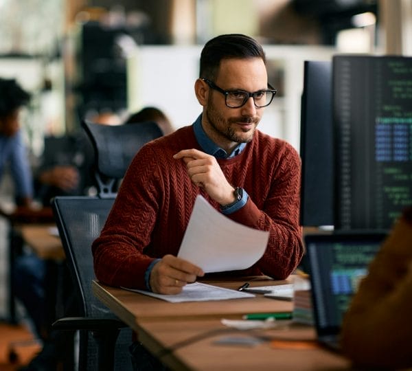 Software engineer using computer while working at IT office.