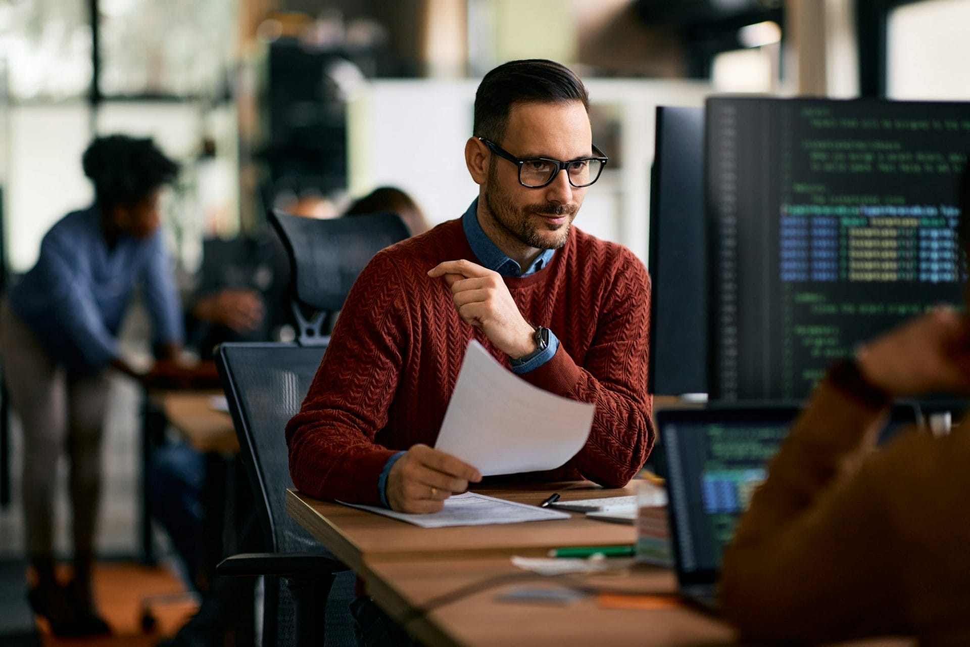 Software engineer using computer while working at IT office.