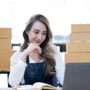 Portrait of Asian young woman SME working with a box at home the workplace.start-up small business