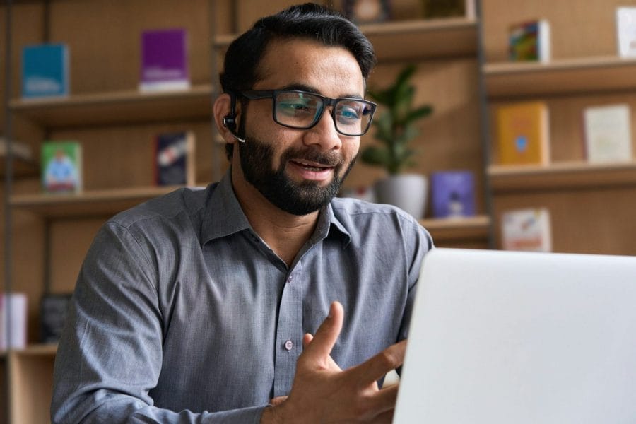 Indian business man speaking having virtual meeting on laptop.